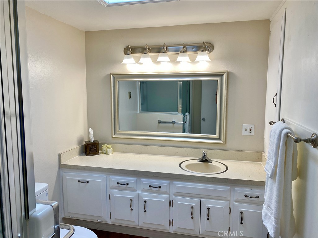 1312 Golden Rain Road Seal Beach, CA 90740 - Photo 3 of 38 bathroom with modern vanity light fixture and skylight
