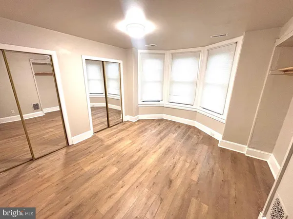 wooden floor in an empty room with a chandelier