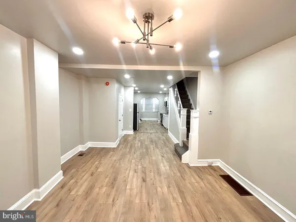 a view of a hallway with wooden floor and staircase