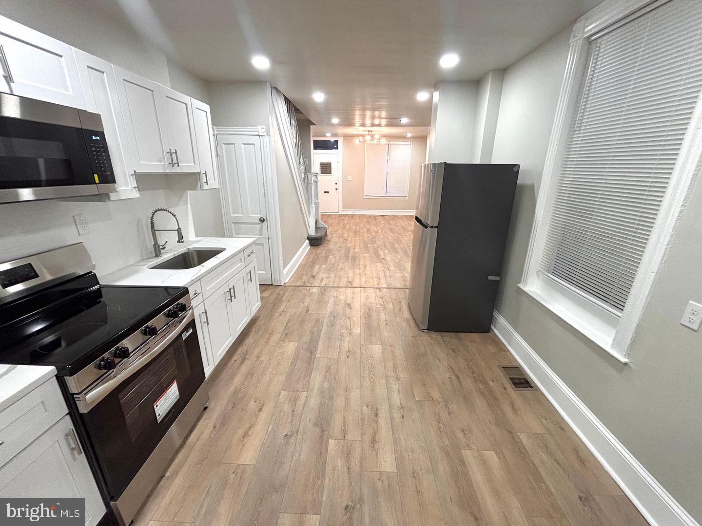 3023 Redner Street Philadelphia, PA 19121 - Photo 18 of 22 a kitchen with stainless steel appliances granite countertop a sink stove and refrigerator
