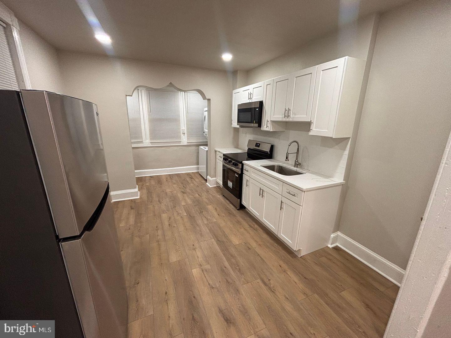 3023 Redner Street Philadelphia, PA 19121 - Photo 19 of 22 a kitchen with stainless steel appliances a refrigerator a sink a stove a microwave a counter top and cabinets