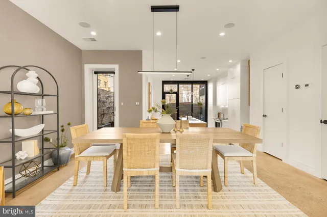 a view of a dining room with furniture a rug and wooden floor