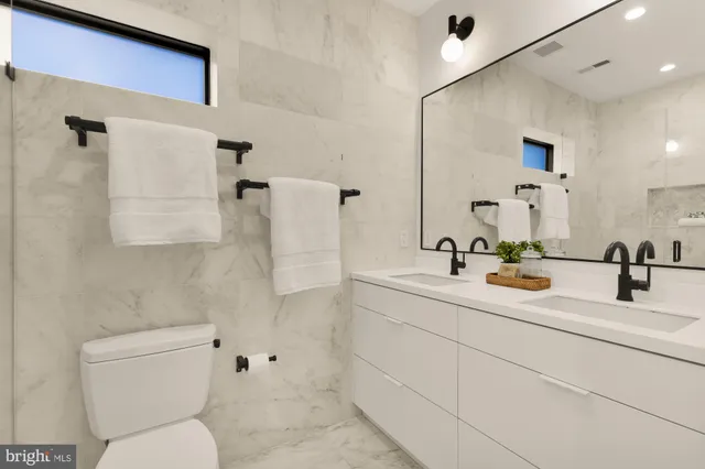 a bathroom with a toilet sink and mirror