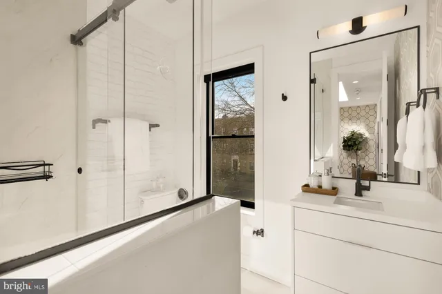 a bathroom with a tub sink and mirror