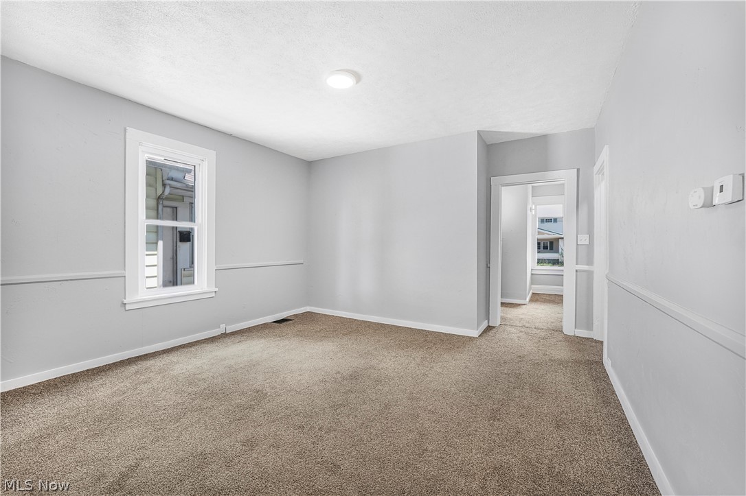 885 Wales Road Northeast Massillon, OH 44646 - Photo 23 of 34 Neutral gray walls complement the textured brown carpeting