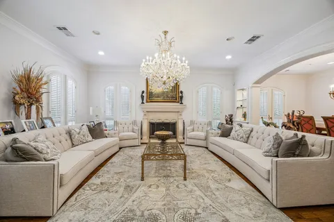 a living room with furniture a fireplace and a chandelier