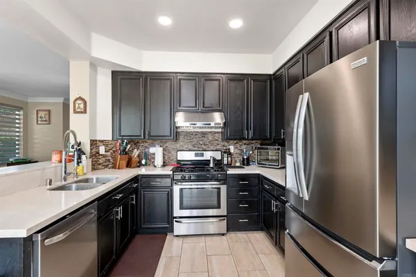 a kitchen with a sink cabinets stainless steel appliances and a counter top space