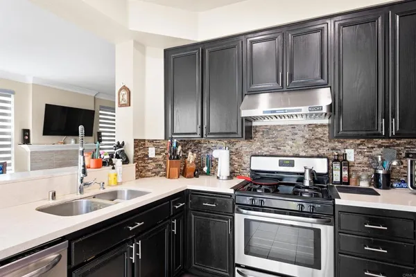 a kitchen with stainless steel appliances a sink stove and microwave