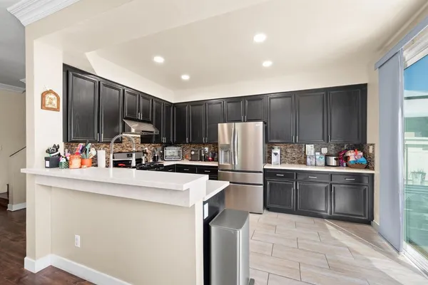 a kitchen with kitchen island a counter top space cabinets and stainless steel appliances