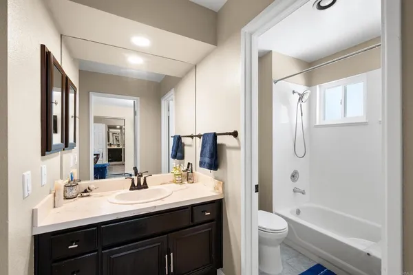 a bathroom with a tub sink toilet and a mirror