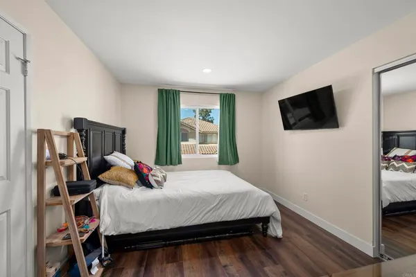 a bedroom with a bed a flat screen tv and a window