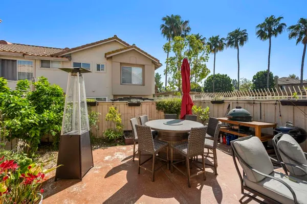a view of a patio with table and chairs potted plants and palm tree