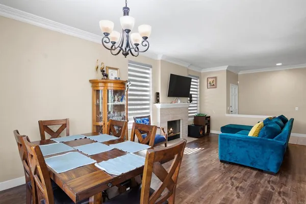 a view of a dining room with furniture a chandelier and wooden floor