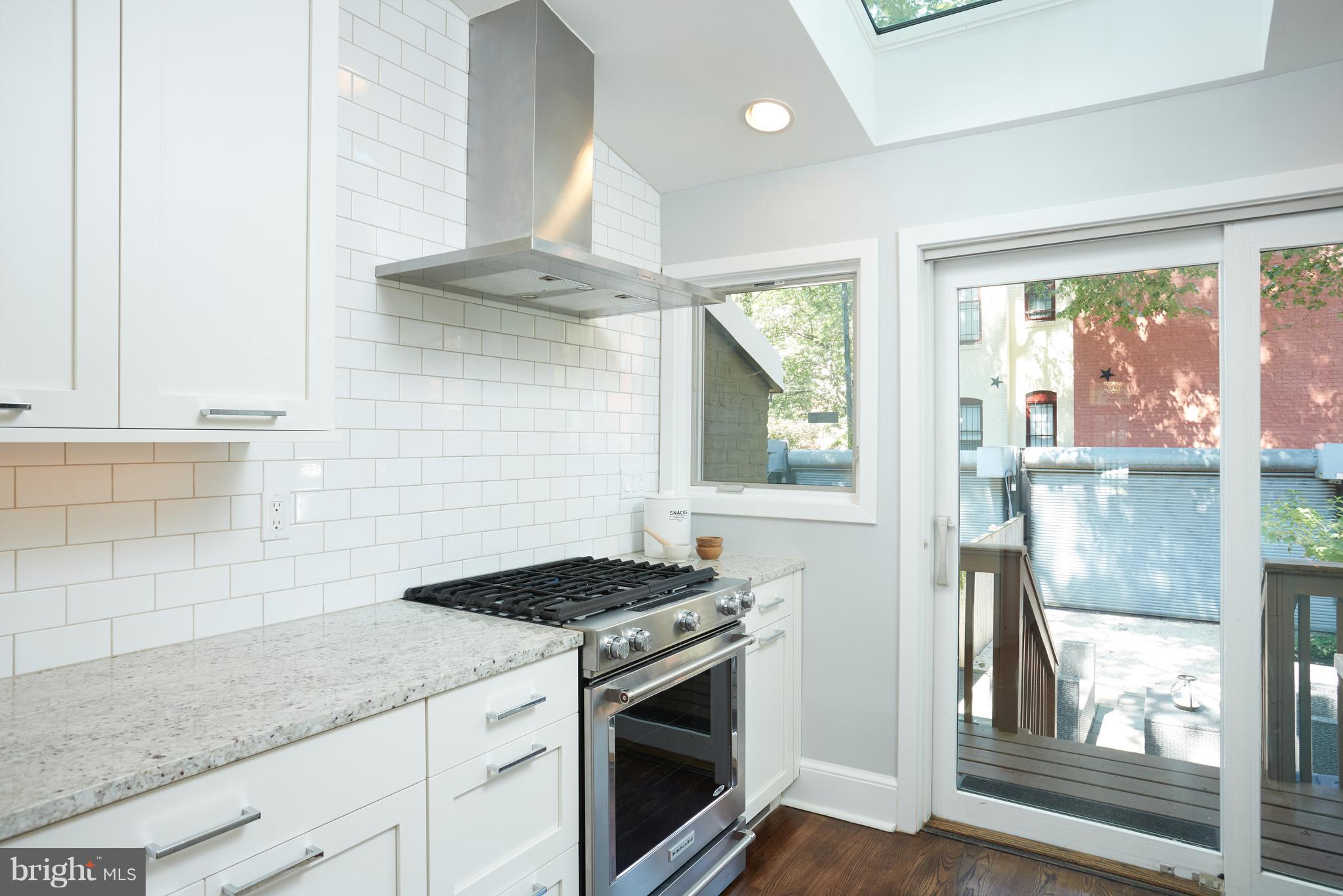 1822 16th Street Northwest Washington, DC 20009 - Photo 9 of 29 a kitchen with granite countertop stainless steel appliances a stove and a white cabinets