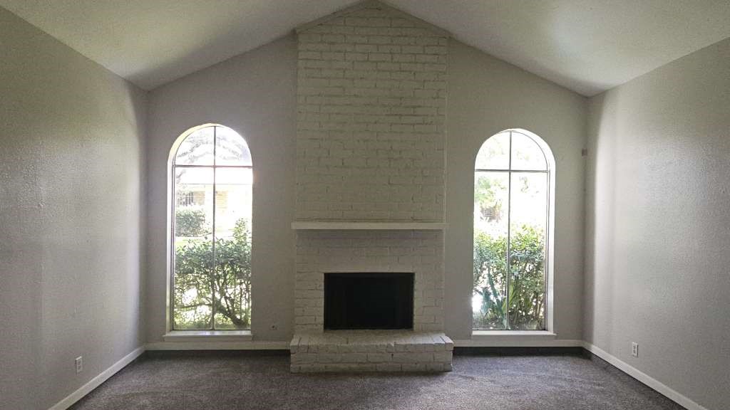 12439 West Village Drive, Unit D Houston, TX 77039 - Photo 2 of 7 a living room with a fireplace and windows