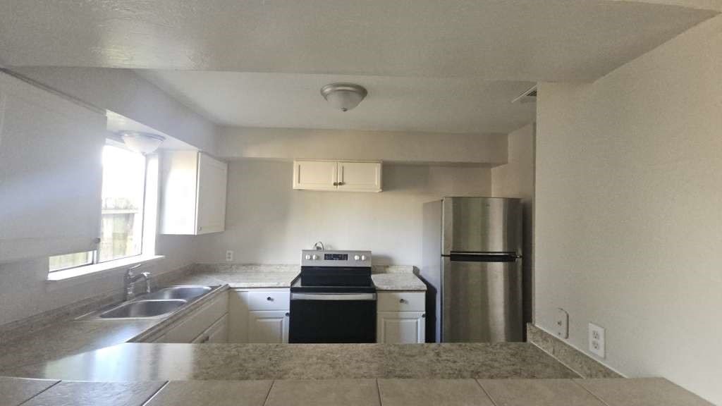12439 West Village Drive, Unit D Houston, TX 77039 - Photo 3 of 7 a kitchen with a refrigerator and a sink
