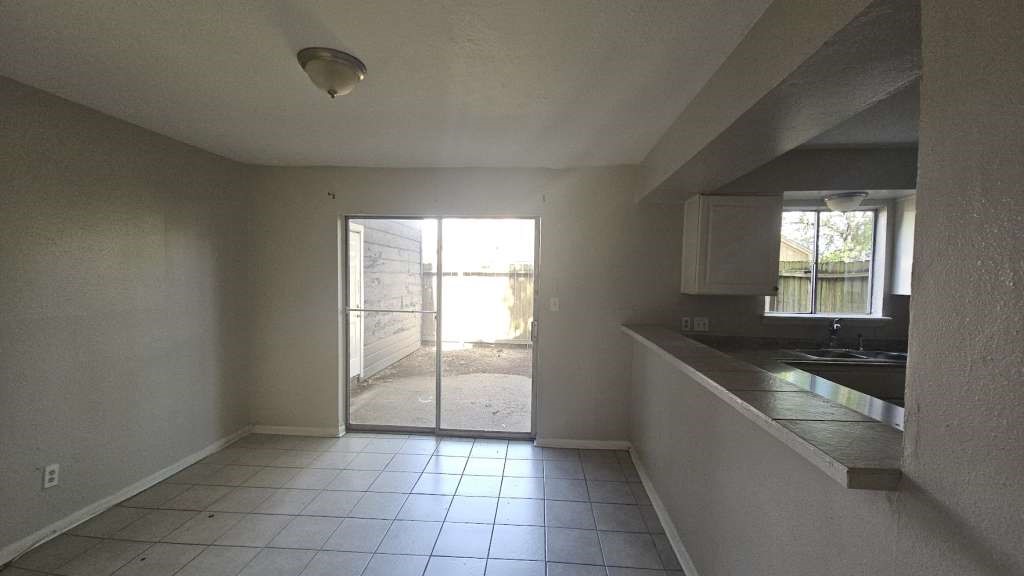 12439 West Village Drive, Unit D Houston, TX 77039 - Photo 4 of 7 a kitchen with granite countertop a sink and a stove