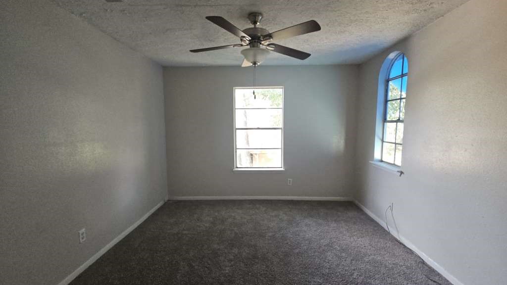 12439 West Village Drive, Unit D Houston, TX 77039 - Photo 5 of 7 an empty room with windows and fan