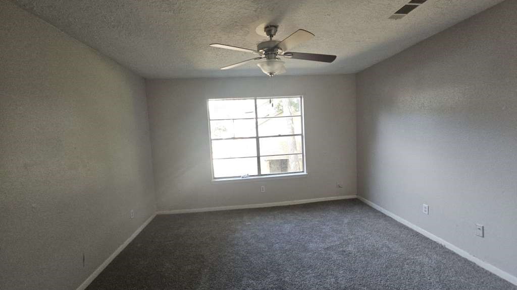 12439 West Village Drive, Unit D Houston, TX 77039 - Photo 6 of 7 an empty room with a window and a fan
