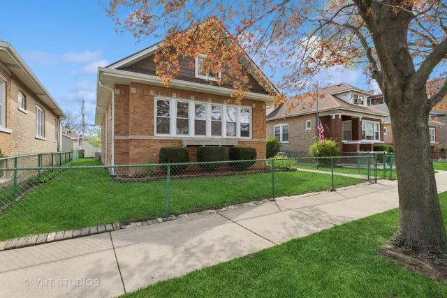 a view of a house next to a yard with big trees