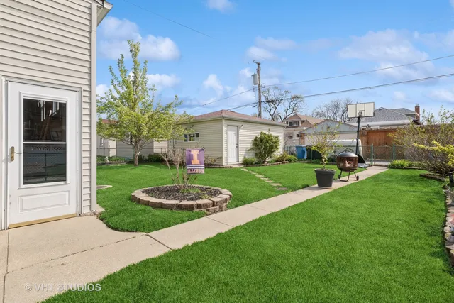 a view of a white house with a yard and potted plants