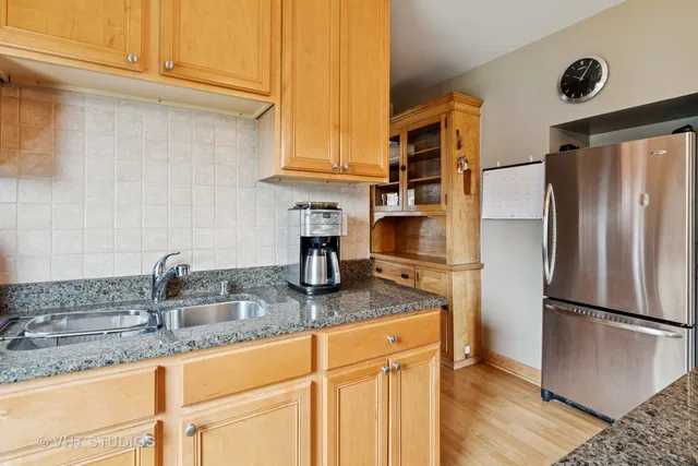 a kitchen with stainless steel appliances granite countertop a refrigerator and a sink