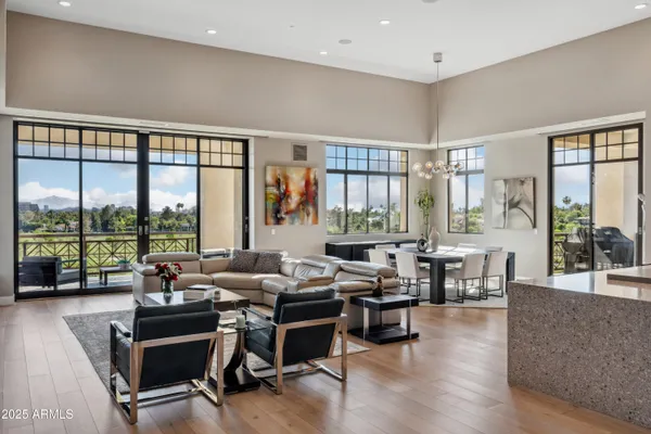 a living room with furniture and floor to ceiling windows