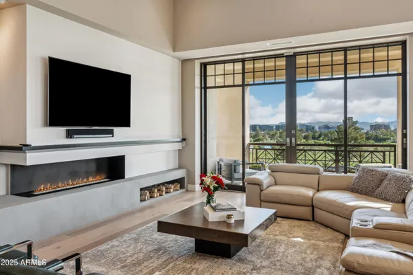 a living room with furniture a flat screen tv and a floor to ceiling window