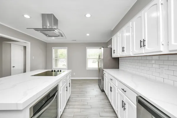 a kitchen with stainless steel appliances granite countertop a sink and dishwasher a stove top oven with white countertops