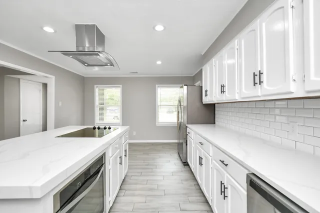 a kitchen with stainless steel appliances granite countertop a sink and dishwasher a stove top oven with white countertops
