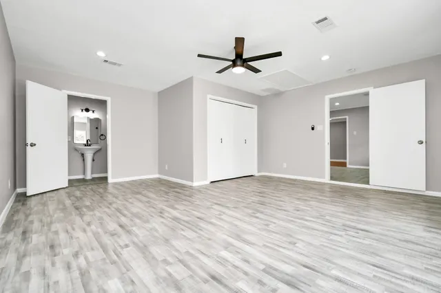 a view of empty room with wooden floor and ceiling fan