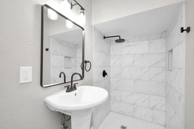 a bathroom with a sink a mirror and shower