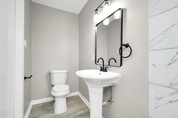 a bathroom with a toilet sink and mirror