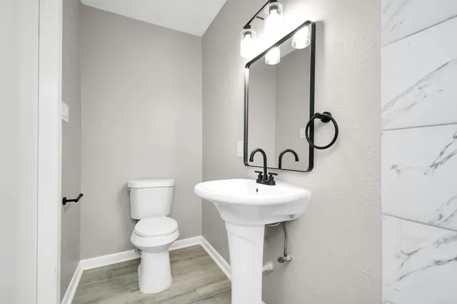 a bathroom with a toilet sink and mirror