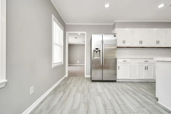 a kitchen with stainless steel appliances a refrigerator and wooden floor