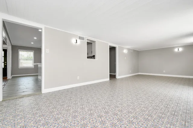 a view of a hallway with wooden floor and a living room