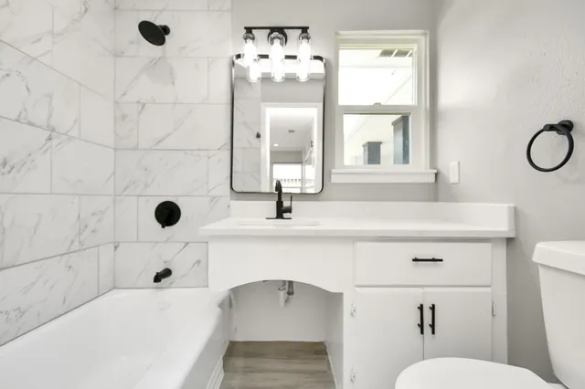 a bathroom with a sink mirror and toilet