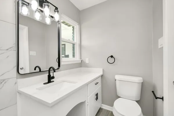 a bathroom with a toilet sink and mirror