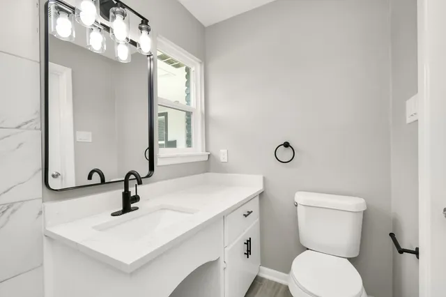 a bathroom with a toilet sink and mirror