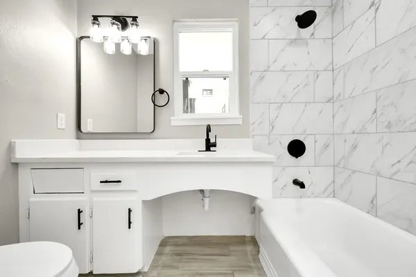 a bathroom with a sink a toilet and shower