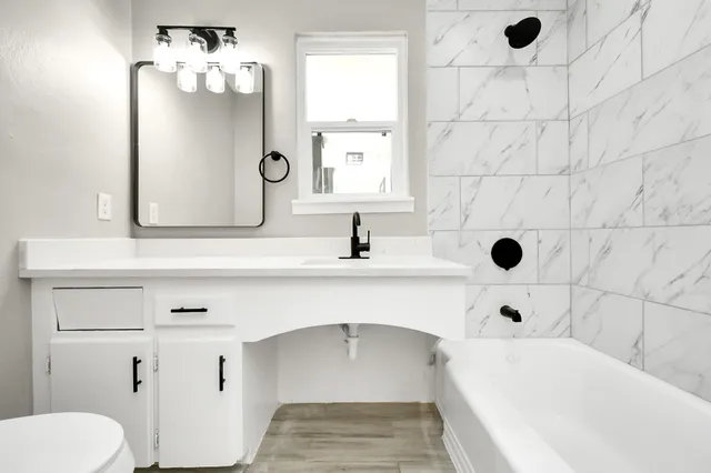 a bathroom with a sink a toilet and shower