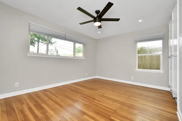 a view of a big room with wooden floor and windows