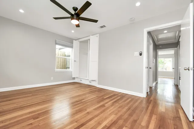 a view of an empty room and window and wooden floor