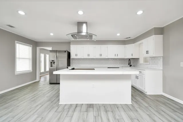 a large kitchen with stainless steel appliances granite countertop a lot of counter space and wooden floors