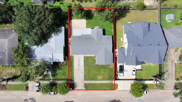 an aerial view of a house with a yard and lake view