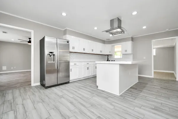 a large kitchen with stainless steel appliances a refrigerator and a stove top oven