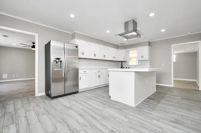 a large kitchen with stainless steel appliances a refrigerator and a stove top oven