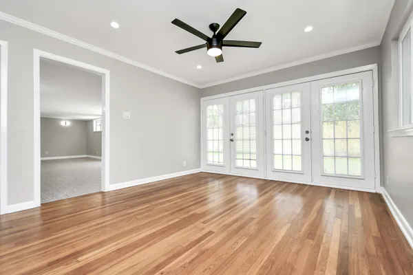 a view of an empty room with a window and wooden floor