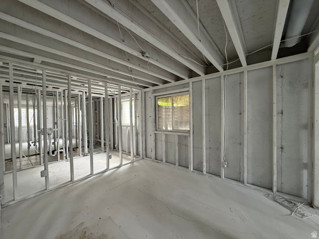 838 East Mountain Road Logan, UT 84321 - Photo 27 of 37 Framed basement area featuring exposed ceiling joists, concrete flooring, and multiple windows providing natural light