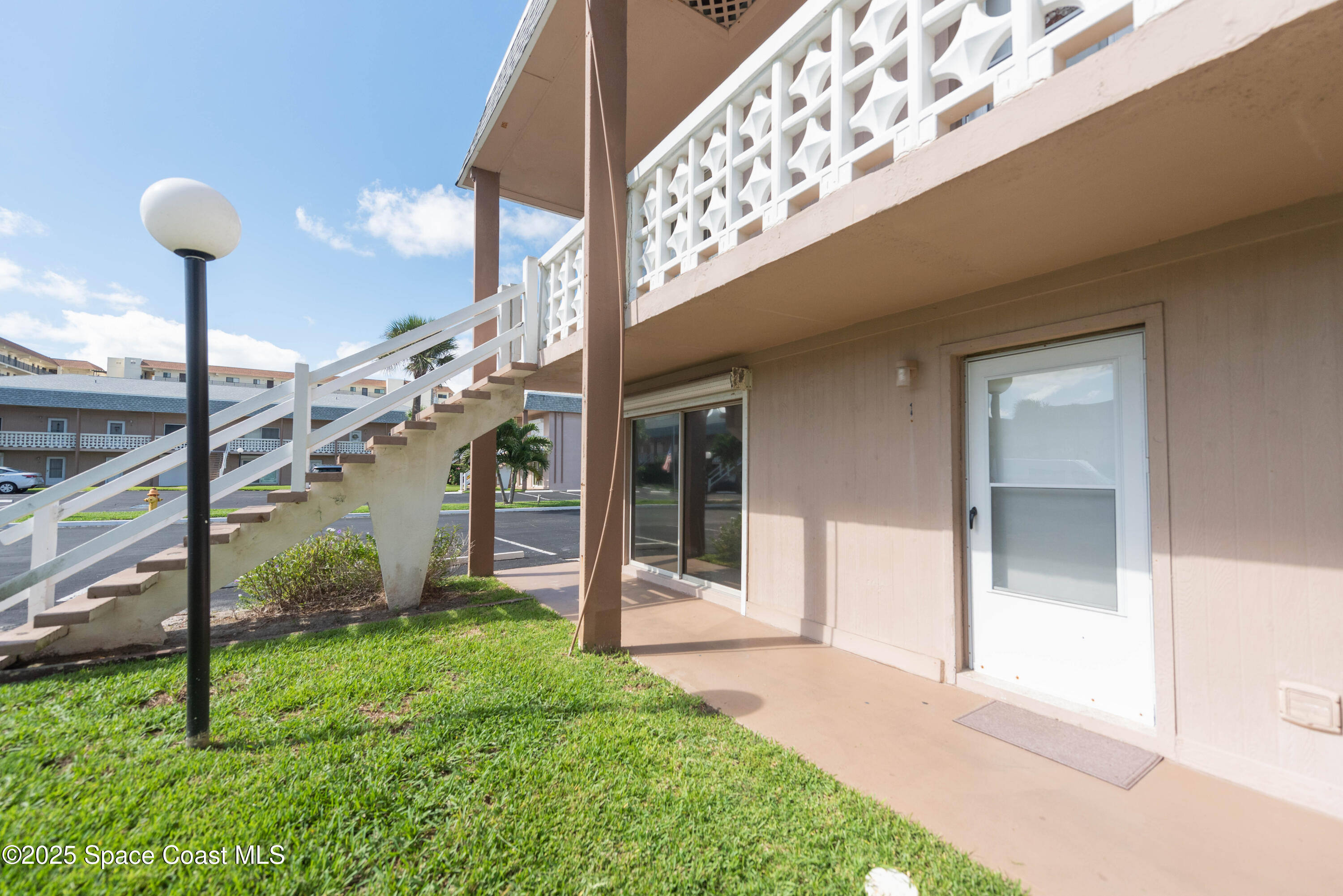 3150 North Atlantic Avenue, Unit 1770 Cocoa Beach, FL 32931 - Photo 18 of 21 a view of a house with a small yard and floor to ceiling window